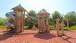 Modern children's playground for outdoor games, a slide pipe made of metal, pyramids made of wood