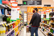 © Austockphoto - male person in grocery store aisle buying juice wearing home made face mask during covid-19 pandemic