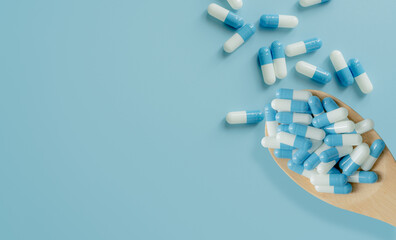 Poster - Top view of blue-white antibiotic capsule pills on wooden spoon and blue background. Antibiotic drug resistance. Prescription drug. Medical care. Pharmaceutical care. Antimicrobial drug overuse.