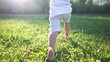 © maxximmm - baby running in the park with bare feet. close-up of the kid leg runs in the summer on the green grass at sunset in the park. happy family kid concept. baby running and playing in the park dream