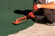 A worker applies a rubber coating to a concrete surface prepared for coating. Rubber crumb obtained in the process of recycling used car tires is used for flooring sports and playgrounds.