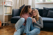 © cherryandbees - mother kiss her daughter while sitting on floor in living room