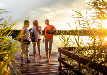 Group of senior woman with yoga mats talking after exercise.