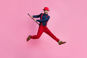 Sticker - Full size photo of excited carefree man hold stick cane jumping isolated on pink color background