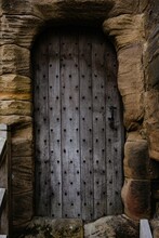 Vertical Shot Of An Ancient Castle Wooden Door Surrounded By Stone