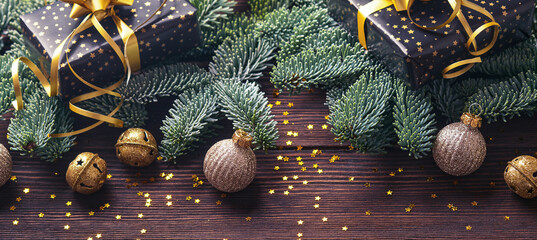 Wall Mural - Christmas fir tree branches, Christmas balls, gift box, wooden snowflakes and stars on old brawn wooden background for your xmas greetings. Top view with copy space. Christmas greeting card. Banner.