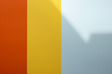 Background Of Red, Yellow And Gray Colors With A Shadow. Colored Vertical Stripes Of Different Widths. Copy Space. 