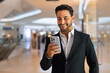 © Ranta Images - Portrait of happy handsome Hispanic businessman using mobile phone while smiling
