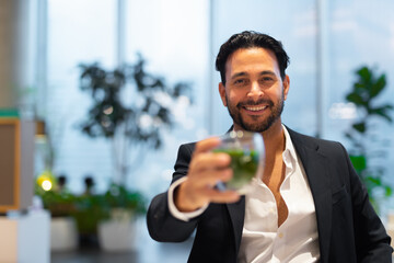 Wall Mural - Portrait of happy handsome Hispanic businessman at coffee shop having green tea