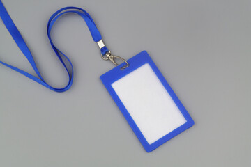 Blue blank badge with string on gray background.