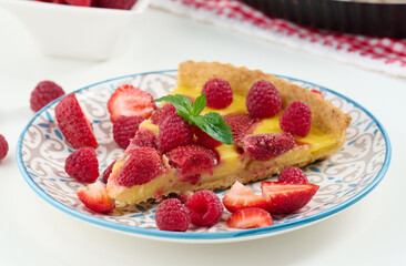 Canvas Print - Round quiche with red strawberries and raspberries on a white table