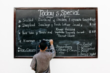 A Server Writes The Day's Specials On A Chalkboard At A Hotel Restaurant.  Siem Reap, Cambodia.