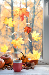 Wall Mural - autumn background. Tea cup, pumpkins, nuts and bright maple leaves on window sill. symbol of fall season. home cozy composition for Halloween, Thanksgiving holidays