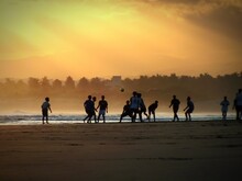 Silhouette People Walking At Beach During Sunset