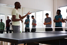 Instructor Interacting With Students During Training Session In Games Room