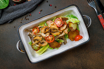 Wall Mural - salad with potatoes and fried mushrooms on brown table top view