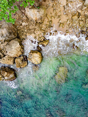 Scenic aerial view of a rocky beach with clear turquoise caribbean water.