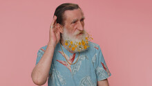 I Cant Hear You. What. Man Trying Hear You, Looking Confused And Frowning, Keeping Arm Near Ear For Louder Voice, Asking To Repeat, To Hear Information, Deafness. Senior Grandfather On Pink Background