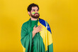 caucasian man with beard, brazilian, soccer fan from brazil, singing national anthem, with hand on chest.