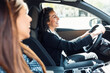 © nenetus - Beautiful businesswoman driving her car while talking with her friend in the city.