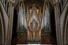 Pipe Organ Of Saint Peter's Cathedral In Geneva, Switzerland, Surrounded By Beautiful Stone Arches.