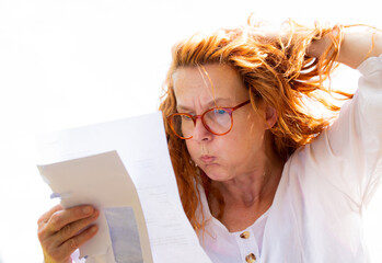 A woman reads a letter with bad news, she reacts emotionally