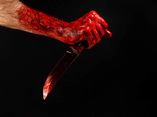 Fototapeta man holding knife with bloody hand on black background. 