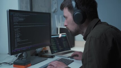 Caucasian man in headphones IT coder programmer software engineer use laptop computer typing code develop program programming java language application on screen web system app development concept.