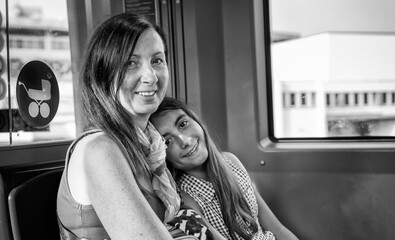 Happy young girl in the subway train smiling with her mother