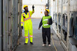 © May Chanikran - Young worker people working job at a warehouse,  Industrial Engineers, Safety Supervisors and Foremen in Hard Hats and Safety Vests Walking in Shipping Cargo Container Terminal Depot.