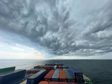Ultra Large Container Vessel At Anchor View On The Forward Part During Stormy Weather And Grey Clouds