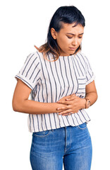 Wall Mural - Young woman wearing casual clothes with hand on stomach because indigestion, painful illness feeling unwell. ache concept.