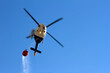 Helicopter putting out a mountain fire, with a bag of water