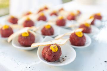 Tuna meatballs with crispy croutons. Gourmet appetizer with raw tuna and bread served on a white background.