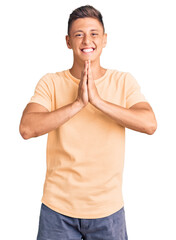 Poster - Young handsome man wearing casual clothes praying with hands together asking for forgiveness smiling confident.