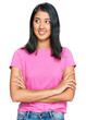 Beautiful asian young woman wearing casual pink t shirt smiling looking to the side and staring away thinking.