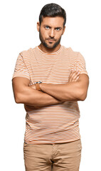 Canvas Print - Handsome hispanic man wearing casual clothes skeptic and nervous, disapproving expression on face with crossed arms. negative person.