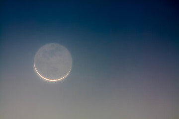 crescent moon showing earthshine at dawn