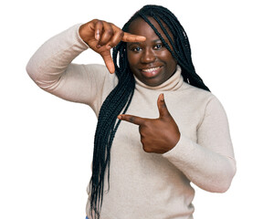 Poster - Young black woman with braids wearing casual winter sweater smiling making frame with hands and fingers with happy face. creativity and photography concept.