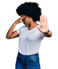 Sticker - Young african american woman wearing casual white t shirt covering eyes with hands and doing stop gesture with sad and fear expression. embarrassed and negative concept.