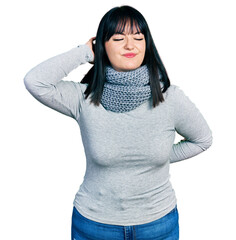 Wall Mural - Young hispanic plus size woman wearing winter scarf suffering of neck ache injury, touching neck with hand, muscular pain