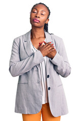 Wall Mural - Young african american woman wearing business clothes smiling with hands on chest with closed eyes and grateful gesture on face. health concept.