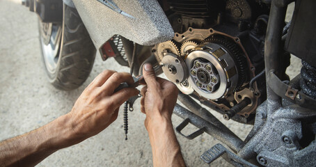 Wall Mural - Mechanic repairing engine of motorcycle. Concept of motorcycle maintenance