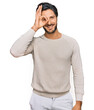 © Krakenimages.com - Young hispanic man wearing casual clothes smiling happy doing ok sign with hand on eye looking through fingers