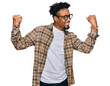 Leinwandbild Motiv Young african american man with beard wearing casual clothes and glasses very happy and excited doing winner gesture with arms raised, smiling and screaming for success. celebration concept.
