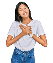 Sticker - Beautiful young asian woman wearing casual white t shirt smiling with hands on chest with closed eyes and grateful gesture on face. health concept.