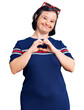 Brunette woman with down syndrome wearing casual clothes smiling in love showing heart symbol and shape with hands. romantic concept.