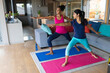 © Wavebreak Media - Biracial mother and daughter practicing warrior 1 pose on mats in living room