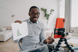 © VK Studio - African american businessperson showing data graph to coworkers via video call online on smartphone