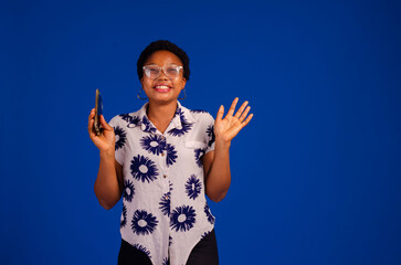 Young african woman isolated on blue background sending a message with the mobile